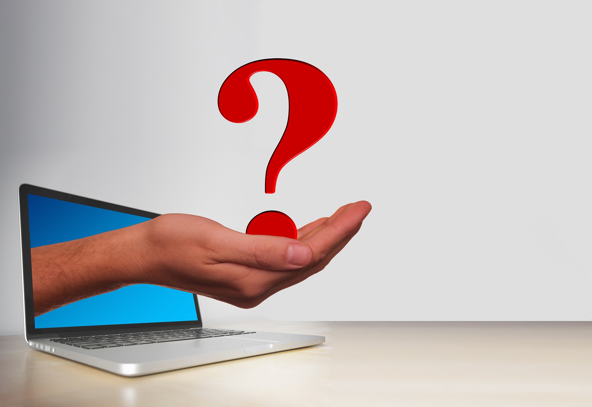 A laptop and a hand coming out of it with a question mark on the hand